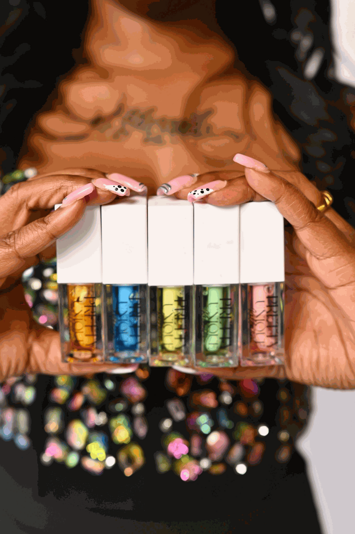 Lip Oil set of five clear tubes with white caps, showing glossy oils in amber, blue, yellow, green and pink